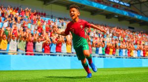 Illustration de Cristiano Ronaldo Junior marquant un but lors d'un match avec l'équipe jeune du Portugal. Image réalisée par IA.
